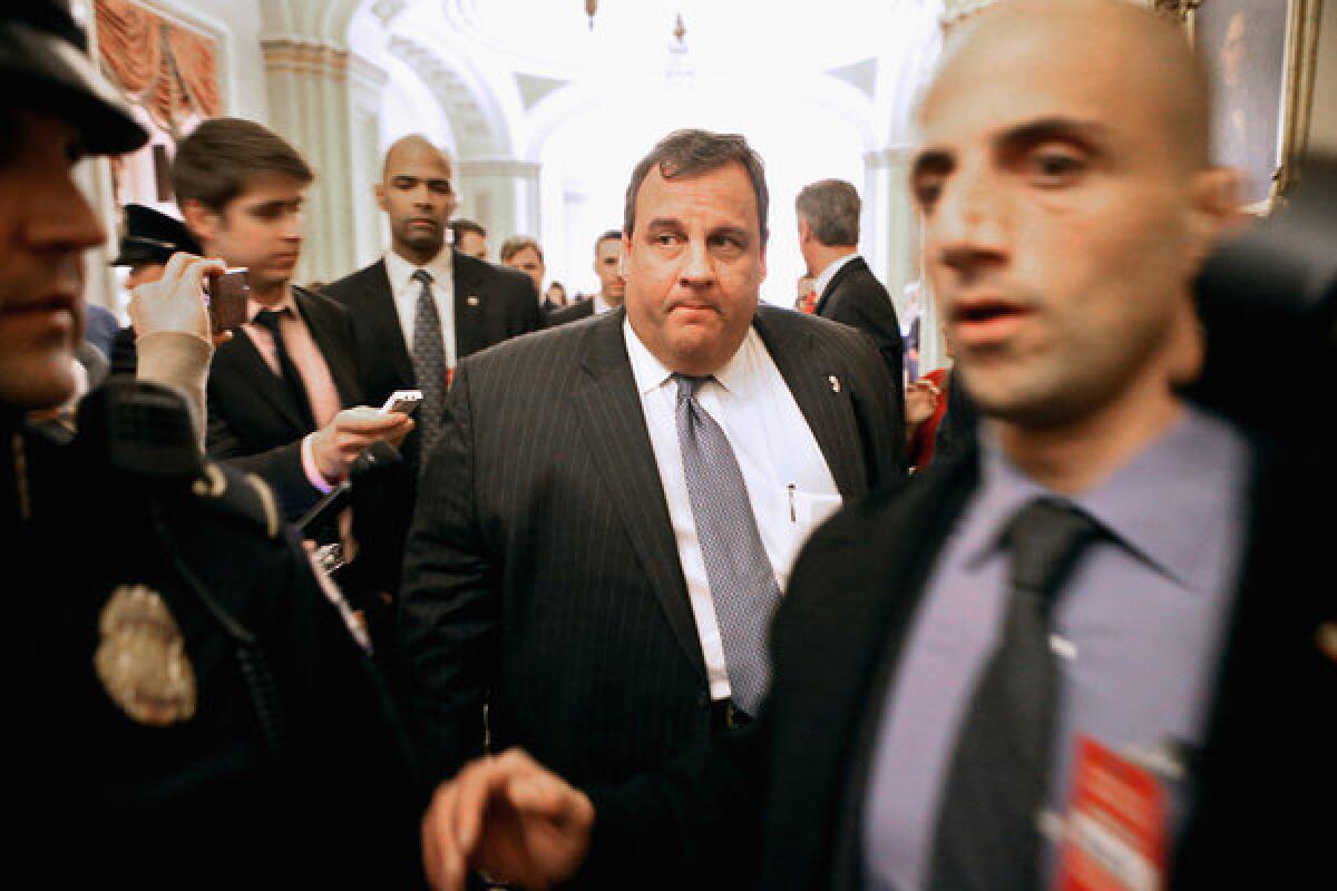 New Jersey Gov. Chris Christie is surrounded by security and journalists as he walks through the Capitol.