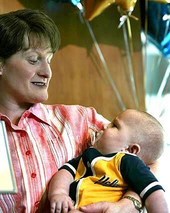 Nicole Draper holds her son, Nate, during a press conference in Los Angeles. Nate and his twin brother Nick have been released from UCLA Medical Center following months of recovery from heart transplant surgery.