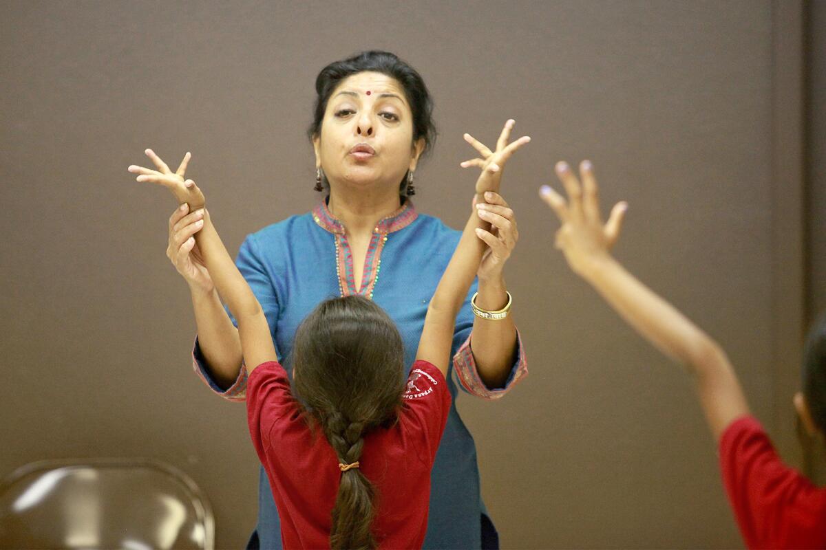 Director Ramya Harishankar, top center, teaches Bharatanatyam, a traditional southern Indian dance style, to a class of girls, ages 5 and 6, at Ektaa Center in Irvine on Tuesday.