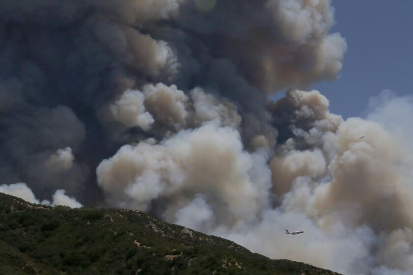 BEAUMONT, CA - AUG.1, 2020. A jumbo jet firefighting plane is dwarfed by the smoke plume of the Apple fire in the hills above Beaumont on Saturday, Aug. 1, 2020. The fire has charred more than 4,000 acres and destroyed at least one home. (Luis Sinco/Los Aneles Time)