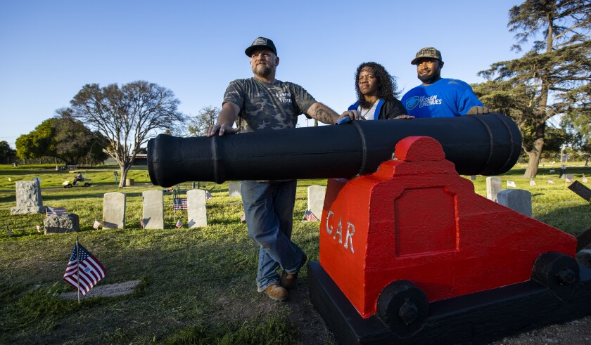 Three people in a cemetery.