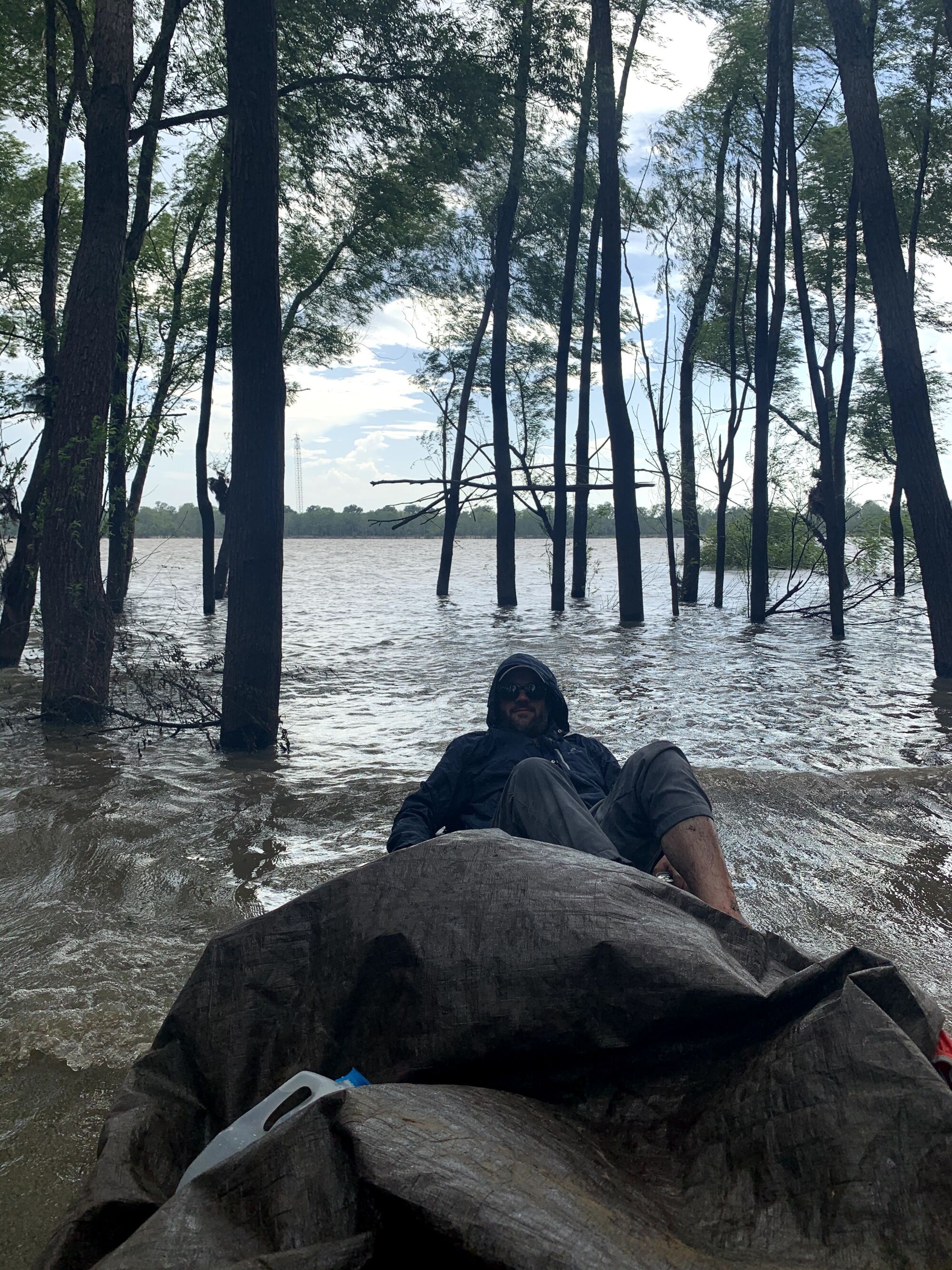 Connor Sheets tries to avoid getting wet in a beached canoe on the banks of the Mississippi River 