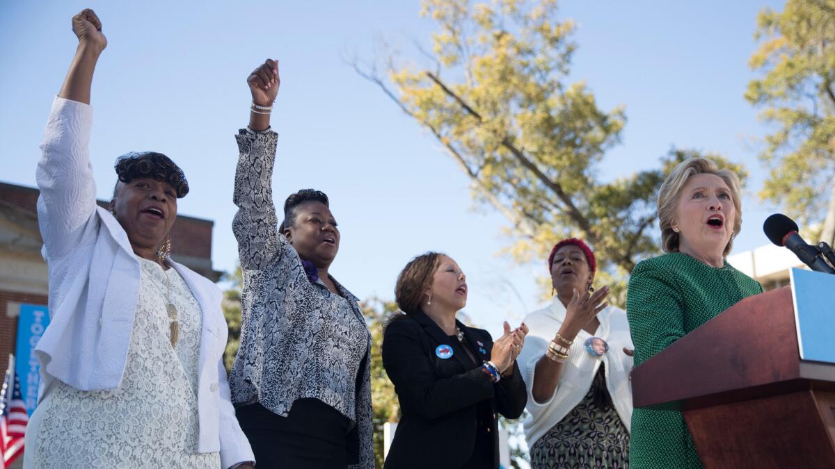 Gwen Carr, mother of Eric Garner; Sybrina Fulton, mother of Trayvon Martin; Lucia McBath, mother of Jordan Davis; and Maria Hamilton, mother of Dontre Hamilton, cheer while Hillary Clinton speaks on Sunday in Raleigh.
