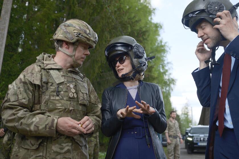 Estonian Prime Minister Kaja Kallas, center, speaks to Brig. Charles Harris, commander of British forces in Estonia, left, and Ross Allen, British ambassador to Estonia, at an undisclosed location in Estonia on Wednesday, May 15, 2024. Kallas was visiting the country's largest defense exercises. (AP Photo/Hendrik Osula)
