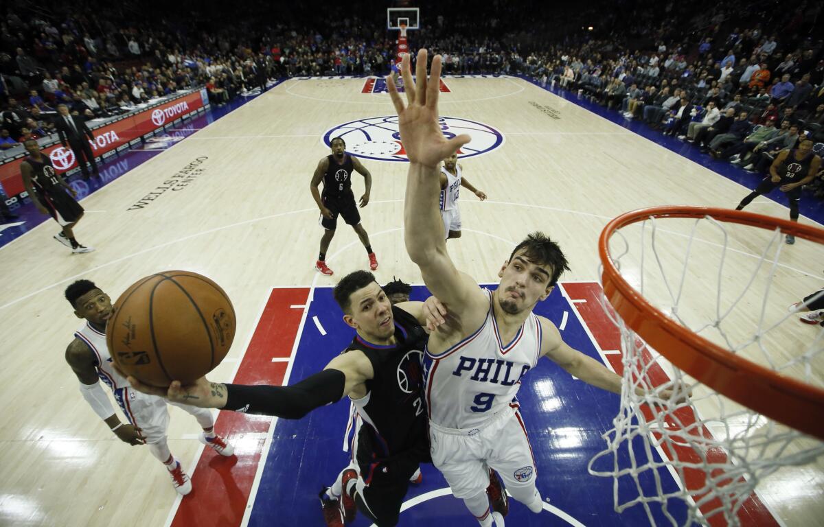 Clippers' Austin Rivers, left, tries to get a shot past Philadelphia's Dario Saric on Jan. 24.