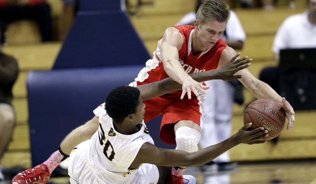 Mater Dei's Rex Pflueger tries to steal the ball from a falledn Franklin Longrus of Bishop O'Dowd during the first half of the Open Division boys' basketball state championship game on Saturday.
