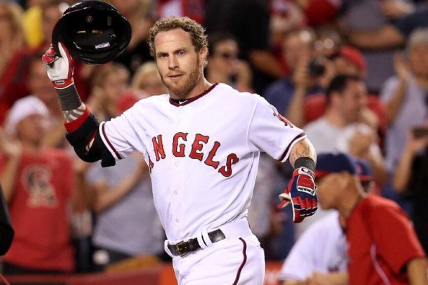 Angels designated hitter Josh Hamilton removes his helmet as he arrives at home plate to begin celebrating his walk-off home run against the Astros on Saturday night.