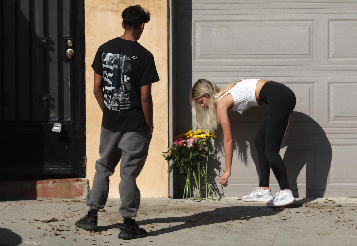 People leave flowers at the scene of a deadly car crash.