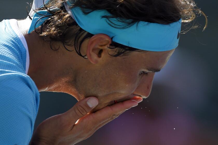 Rafael Nadal of Spain wipes sweat from his face before serving to Novak Djokovic of Serbia during a semifinal match of the BNP Paribas Open on March 19.
