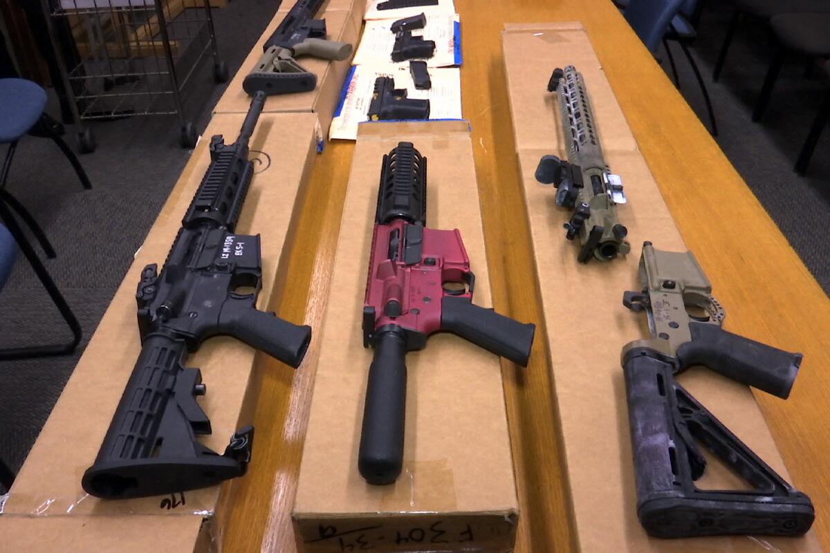 "Ghost guns" on display on boxes on a table.