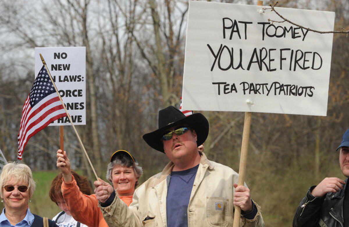 Protester Greg Hetherington demonstrates outside GOP Sen. Patrick J. Toomey's office in Johnstown, Pa., on Tuesday.