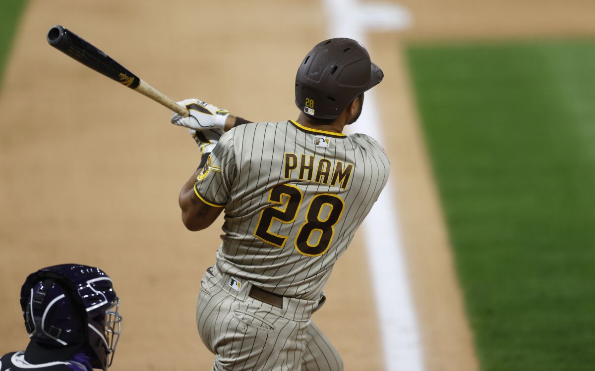 San Diego Padres' Tommy Pham follows the flight of his three-run home run off Colorado Rockies relief pitcher Wade Davis in the ninth inning of a baseball game Friday, July 31, 2020, in Denver. (AP Photo/David Zalubowski)