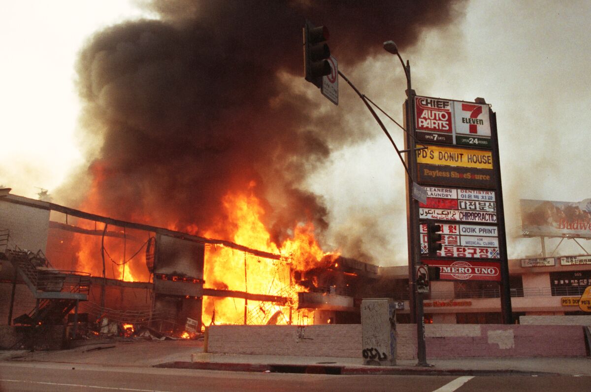 A corner shopping center engulfed in flames.