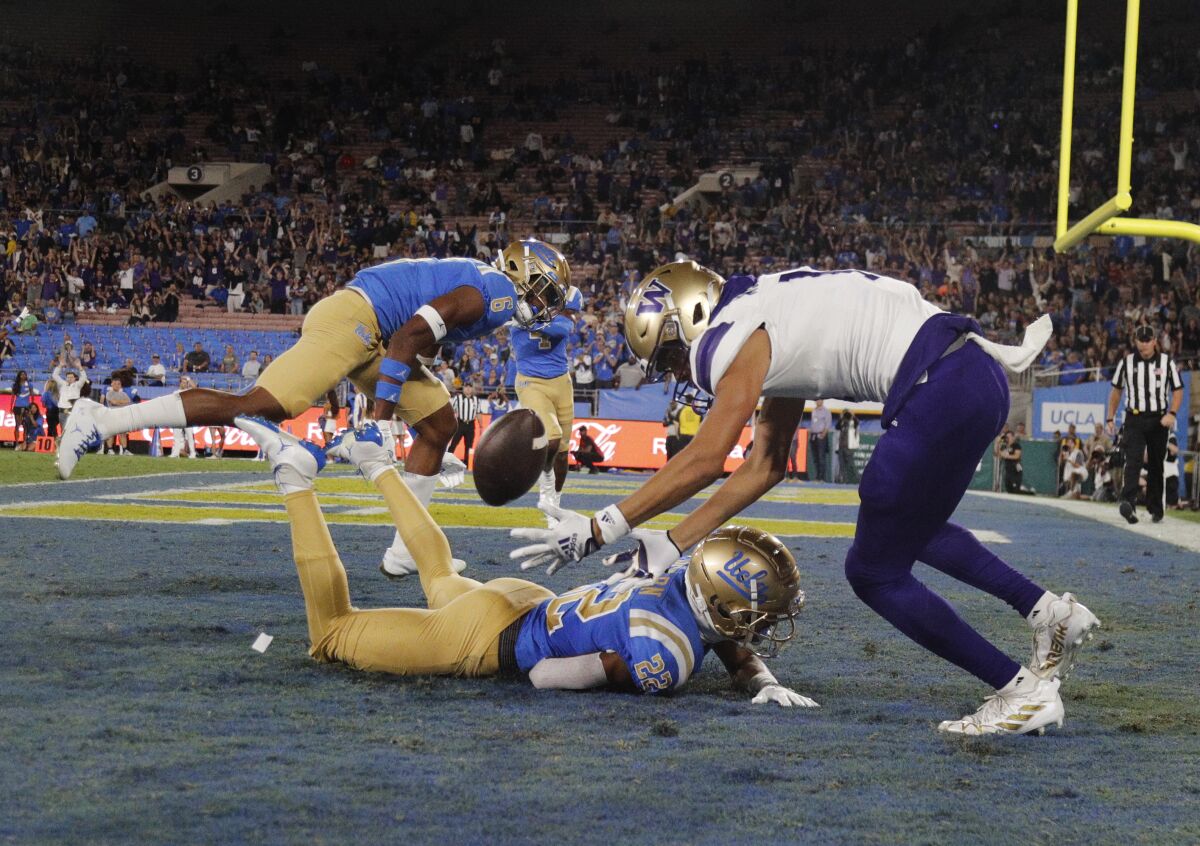 Le demi défensif de l'UCLA, Azizi Hearn, brise une passe dans la zone des buts destinée au receveur large de Washington Jalen McMillan.