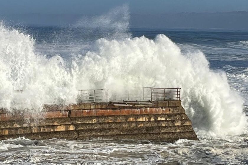 Big waves smack the seawall at the Children's Pool during recent stormy weather, causing damage to a safety railing.