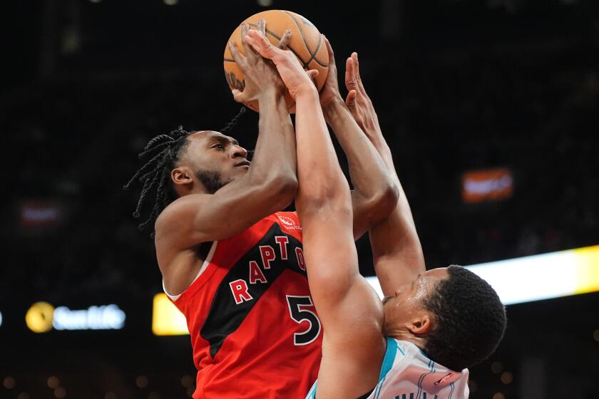 Grant Williams, derecha, de los Hornets de Charlotte, defiende ante Immanuel Quickley (5), de los Raptors de Toronto, durante la segunda mitad del juego de baloncesto de la NBA, el domingo 3 de marzo de 2024, en Toronto. (Frank Gunn/The Canadian Press vía AP)