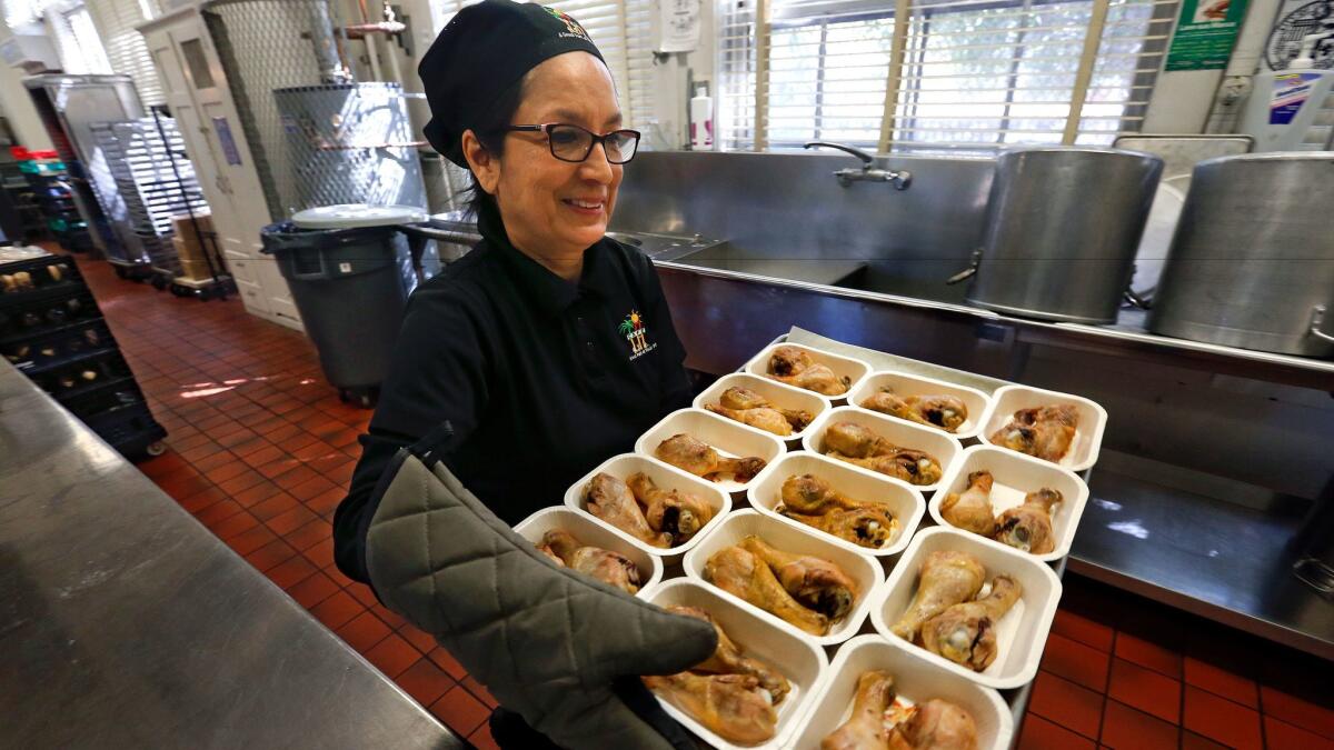 When it comes to higher standards for school food, L.A. Unified says: "Bring it on." The district is ready with such dishes as baked chicken drumsticks, carried here by senior cafeteria manager Anita Gonzales at Belvedere Elementary School.