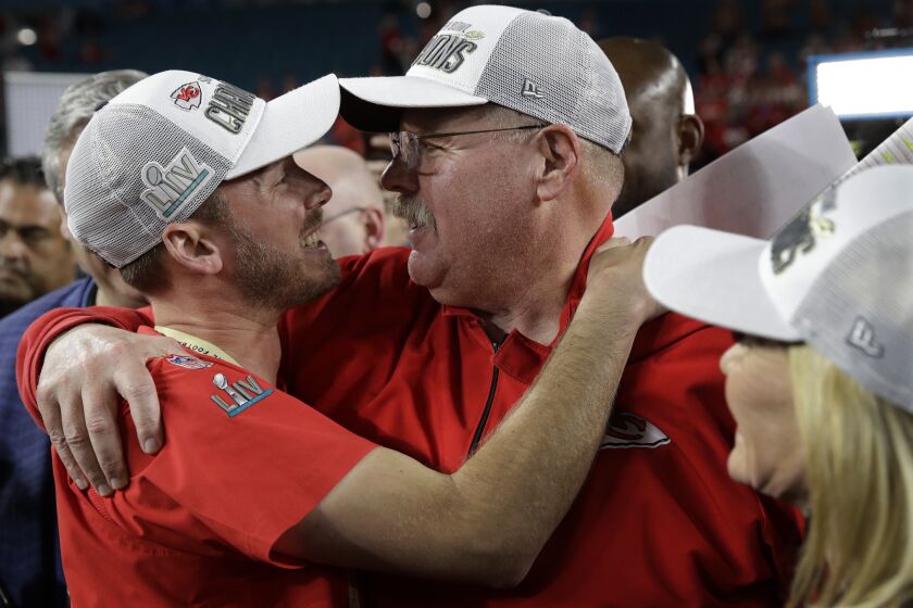 Kansas City Chiefs head coach Andy Reid embraces his son and is son Britt Reid, linebacker coach.