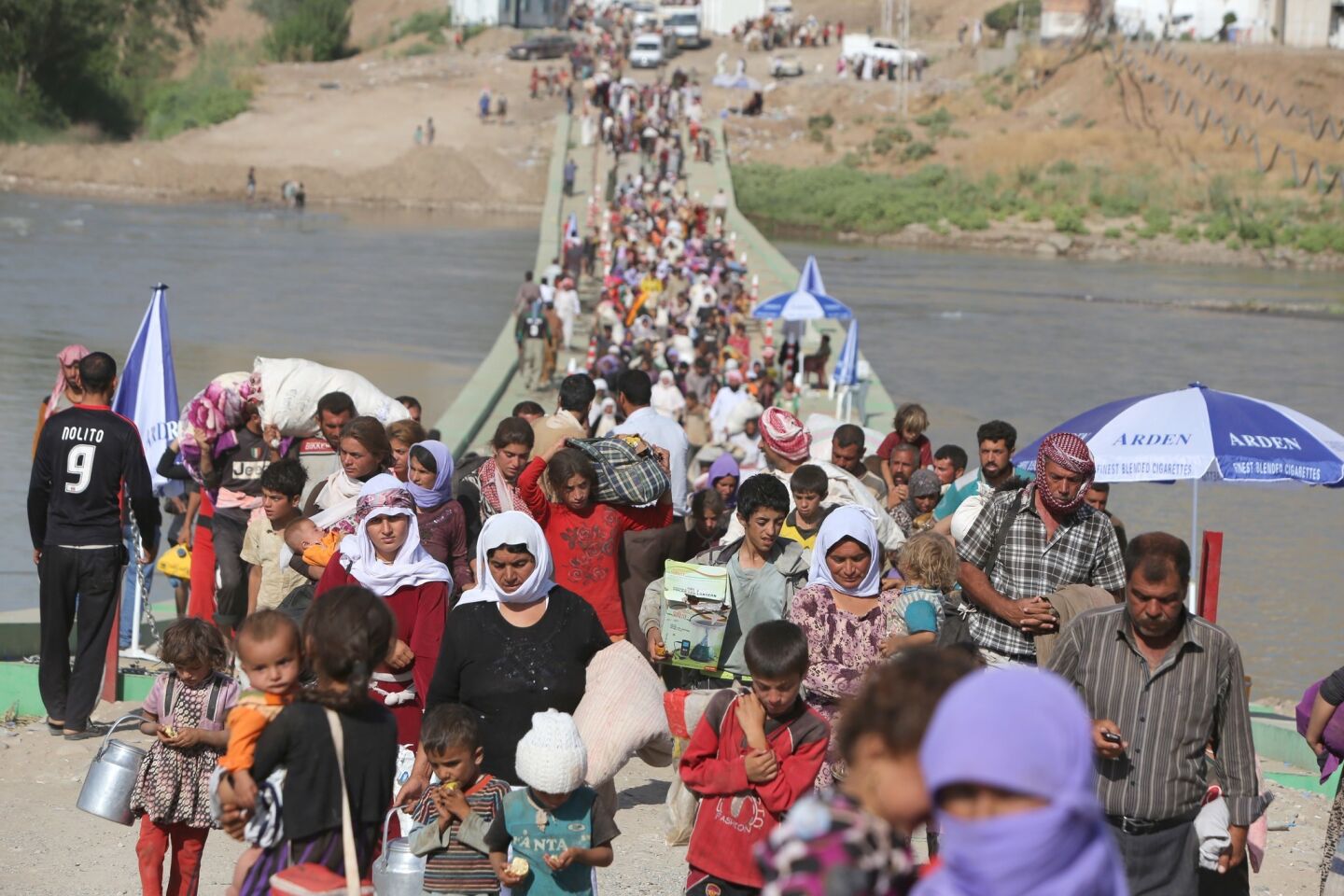 Displaced Iraqis from the Yazidi community cross the Fishkhabur bridge into Syria to be escorted by Kurdish forces to their semi-autonomous zone in northern Iraq.