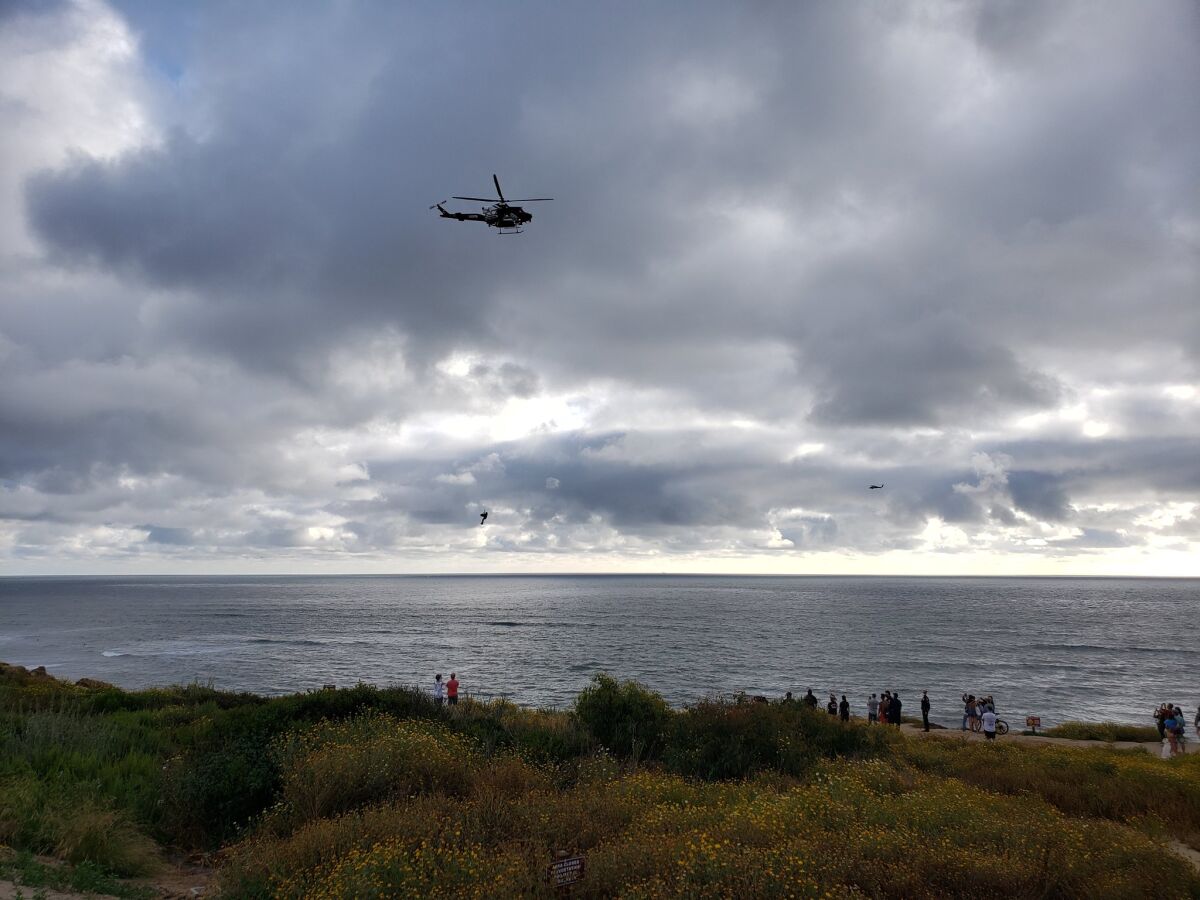 A San Diego Fire-Rescue Department helicopter hoists a woman after she fell Tuesday evening at Sunset Cliffs.