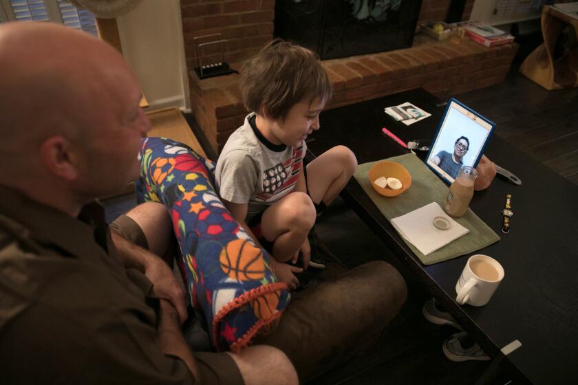 Jason Rochester and his son Ashton Rochester, 6, Face Time with his wife Cecilia Rochester in Mexico, from their home in Roswell, Georgia on May 14, 2019.(Photography by Chris Aluka Berry/ The LA Times)