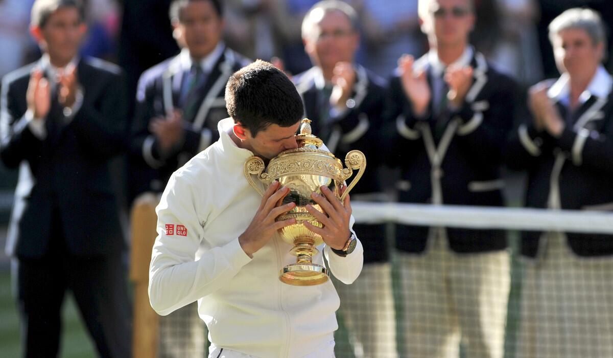 Novak Djokovic kisses the winner's trophy after beating Roger Federer in the Wimbledon men's singles final on Sunday.