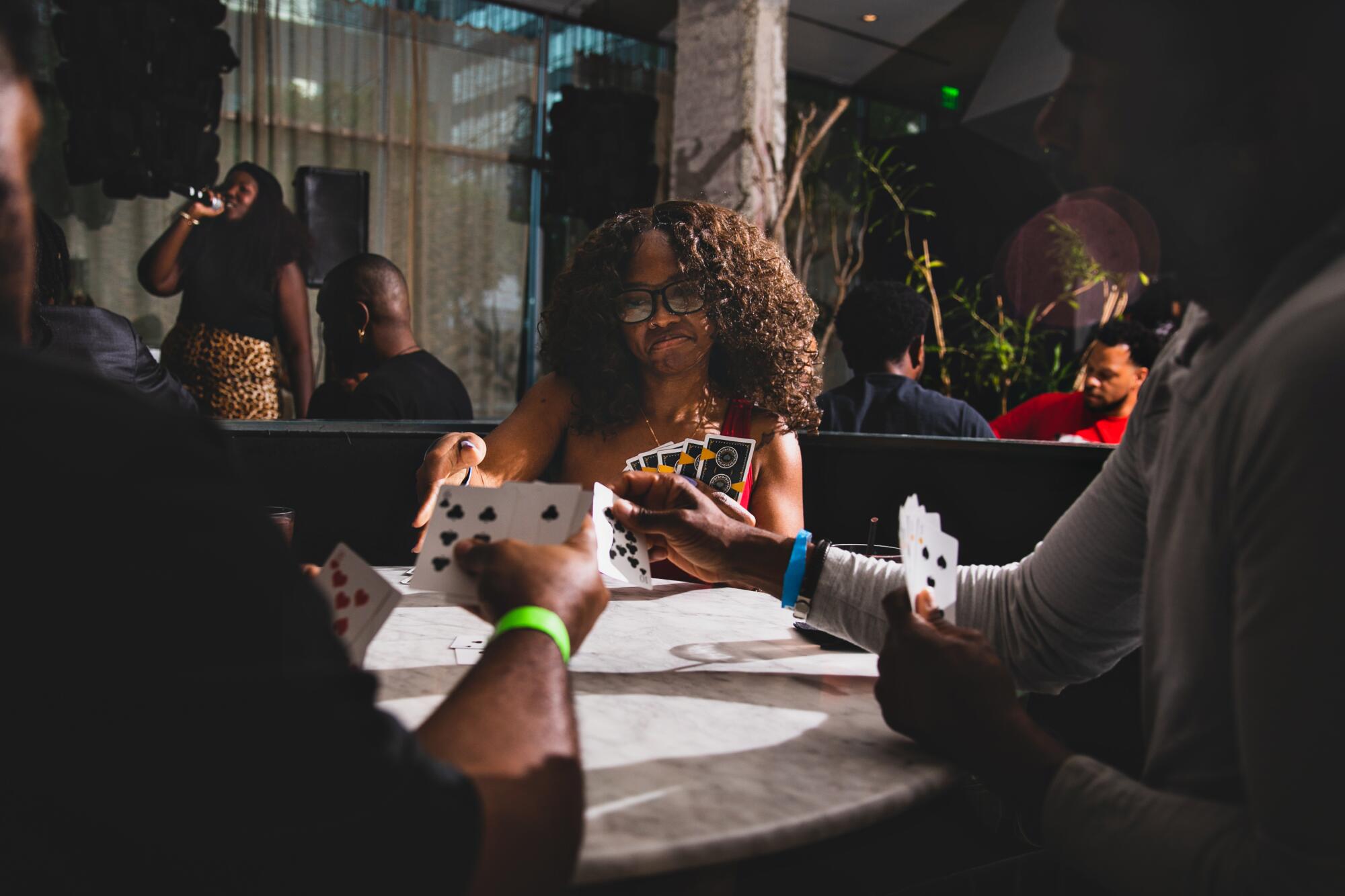 A table of players holding cards in their hands