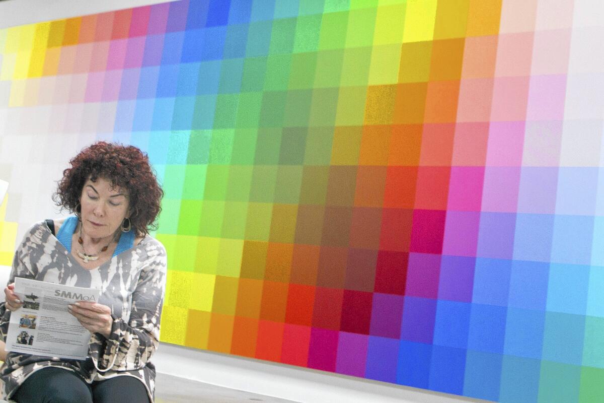 A woman listens to a live performance while interacting with the large visual installations at the Santa Monica Museum of Art Bergamont Station.