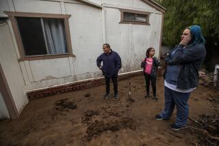WEST HILLS, CA-February 8, 2024:Dakota Rivas, 32, her husband Walter, 42, and daughter Maleeyah, 9, stand in back of their modular home in West Hills that was damaged as a result of a landslide from all the recent rain. Compounding the situation is the fact that they had no renters insurance because no company would insure them due to their precarious location in a flood and wildfire zone. (Mel Melcon / Los Angeles Times)
