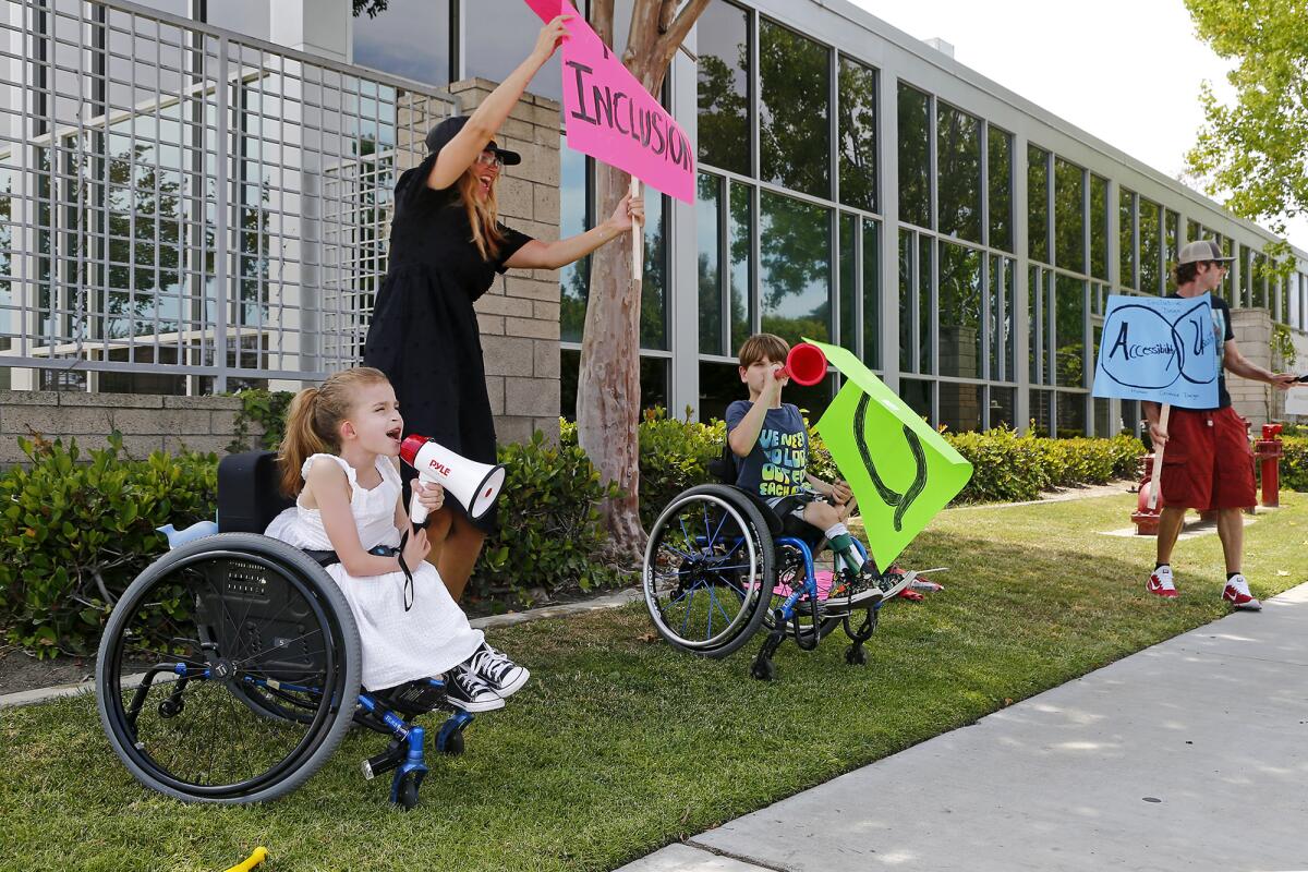 People with signs in front of school