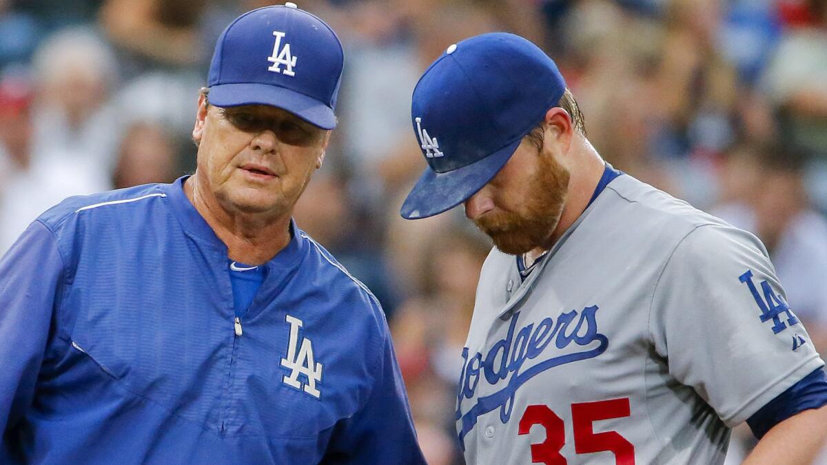 Dodgers pitching coach Rick Honeycutt, left, speaks with starting pitcher Brett Anderson during the first inning of Tuesday's loss to the Atlanta Braves.