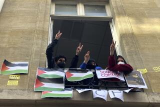 Estudiantes de la Universidad de Ciencias Políticas hace el gesto de la victoria con la mano desde una ventana del centro, en París, el 26 de abril de 2024. (AP Foto/Jeffrey Schaeffer)