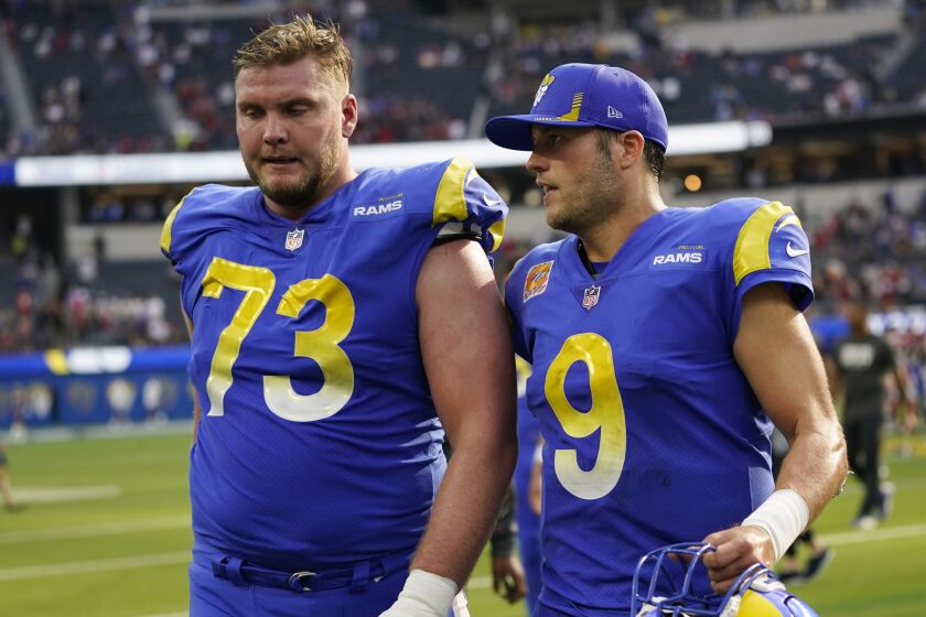 Los Angeles Rams quarterback Matthew Stafford walks off the field with offensive tackle David Edwards.
