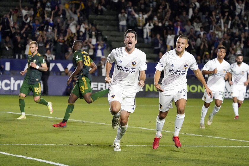 Galaxy midfielder Sacha Kljestan, center, celebrates after scoring on a penalty kick in stoppage time.