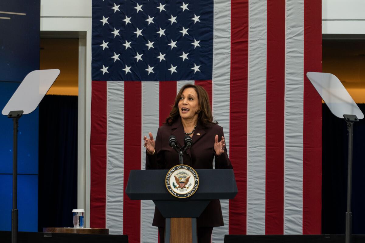 Kamala Harris speaks at a lectern in front of an American flag