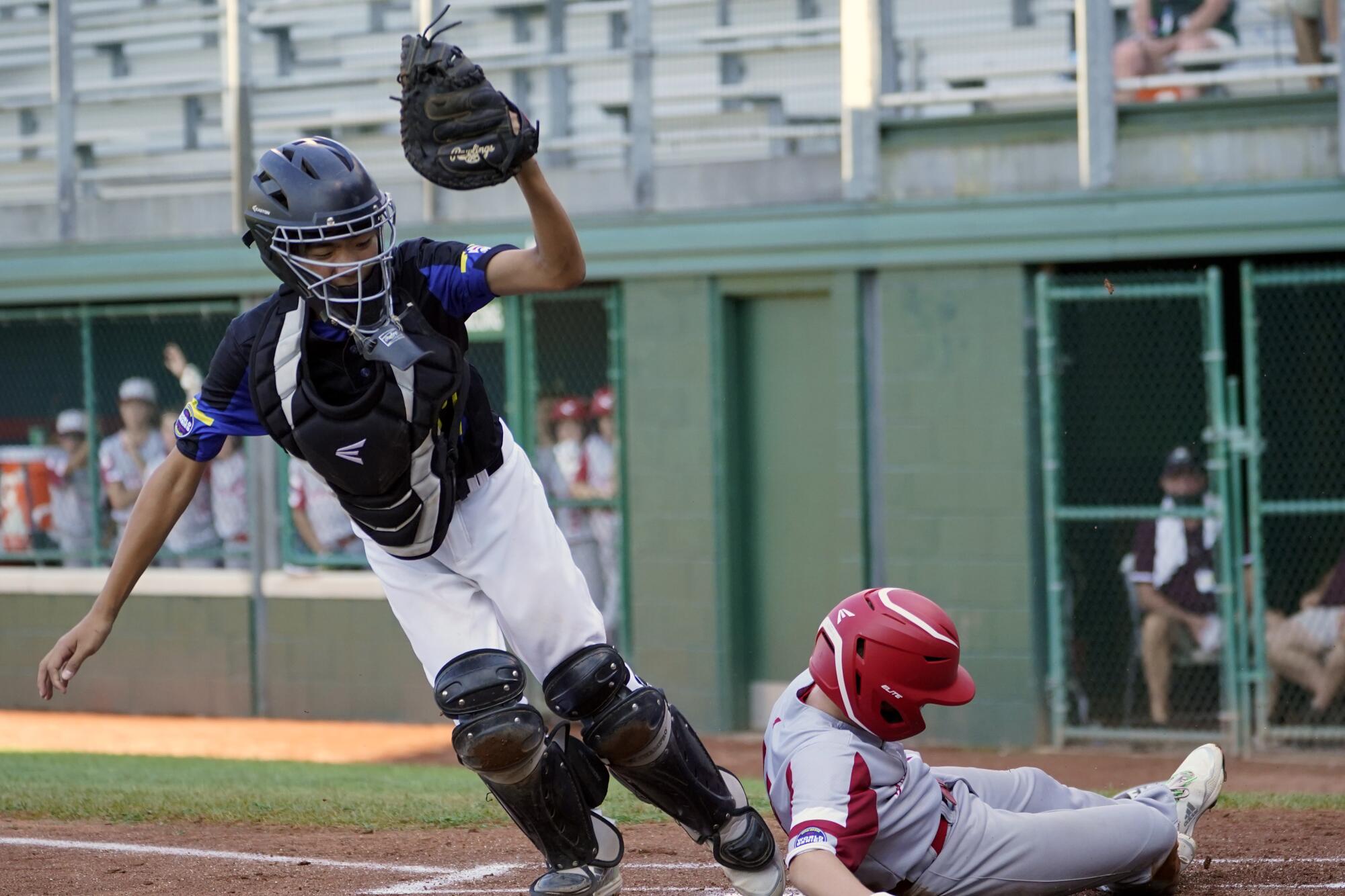 Sioux Falls, S.D.'s Boston Bryant scores next to Torrance, Calif., catcher Andrew Nuruki.