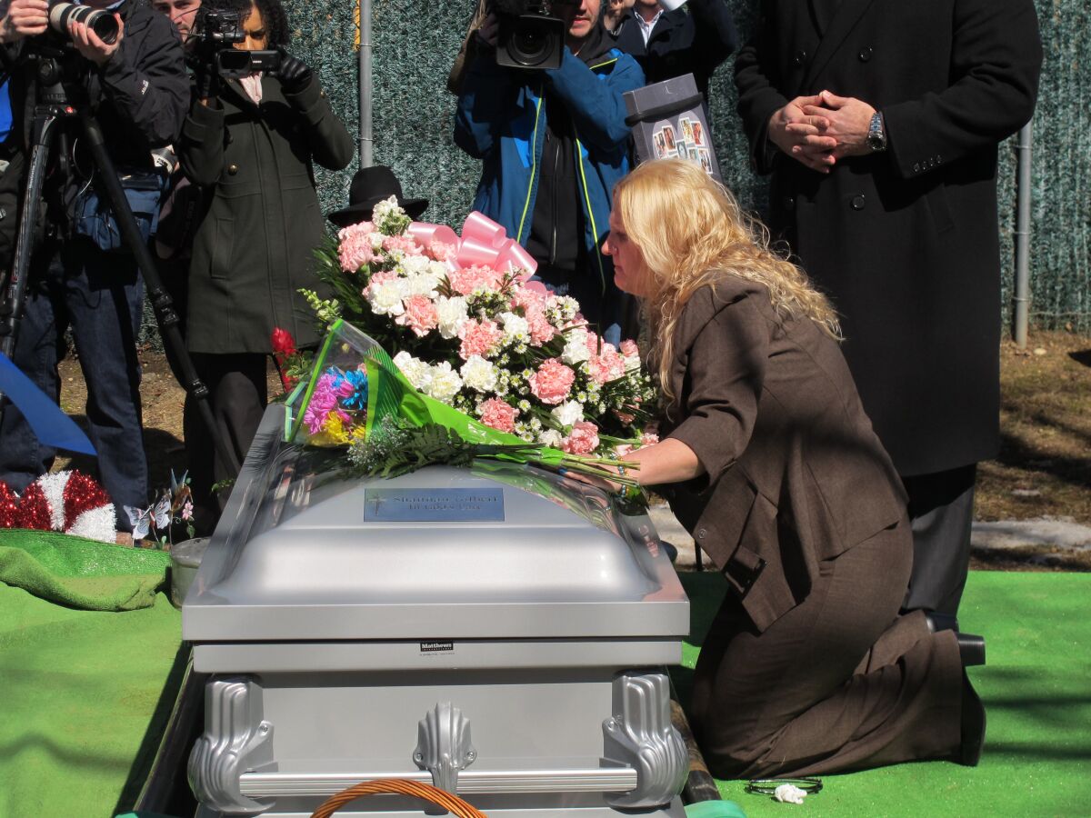 FILE — Mari Gilbert prays over the coffin of her daughter, Shannan Gilbert, at Amityville Cemetery in Amityville, N.Y., March 12, 2015. Gilbert, whose disappearance in a Long Island beach community more than a decade ago sparked an investigation into a possible serial killer said “there's somebody after me" in a newly released 911 tape. But Suffolk County police said Friday, May 13, 2022, that they still believe that Gilbert's death near Gilgo Beach was a "tragic accident" and unconnected to the slayings of multiple other women whose remains were found in the same area in 2010 and 2011. (AP Photo/Frank Eltman, File)