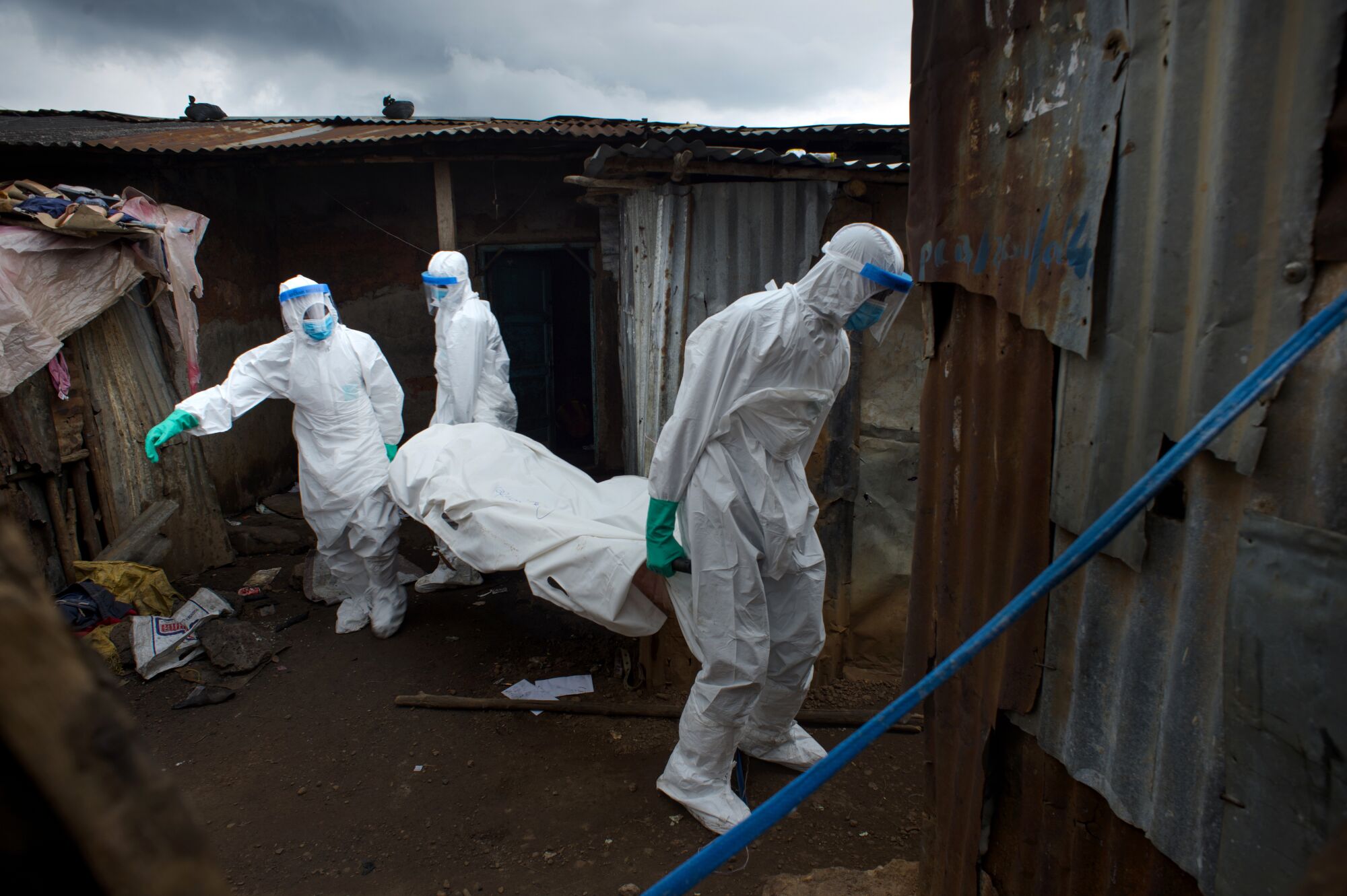 Burial workers remove a body in Freetown, Sierra Leone, in 2014.