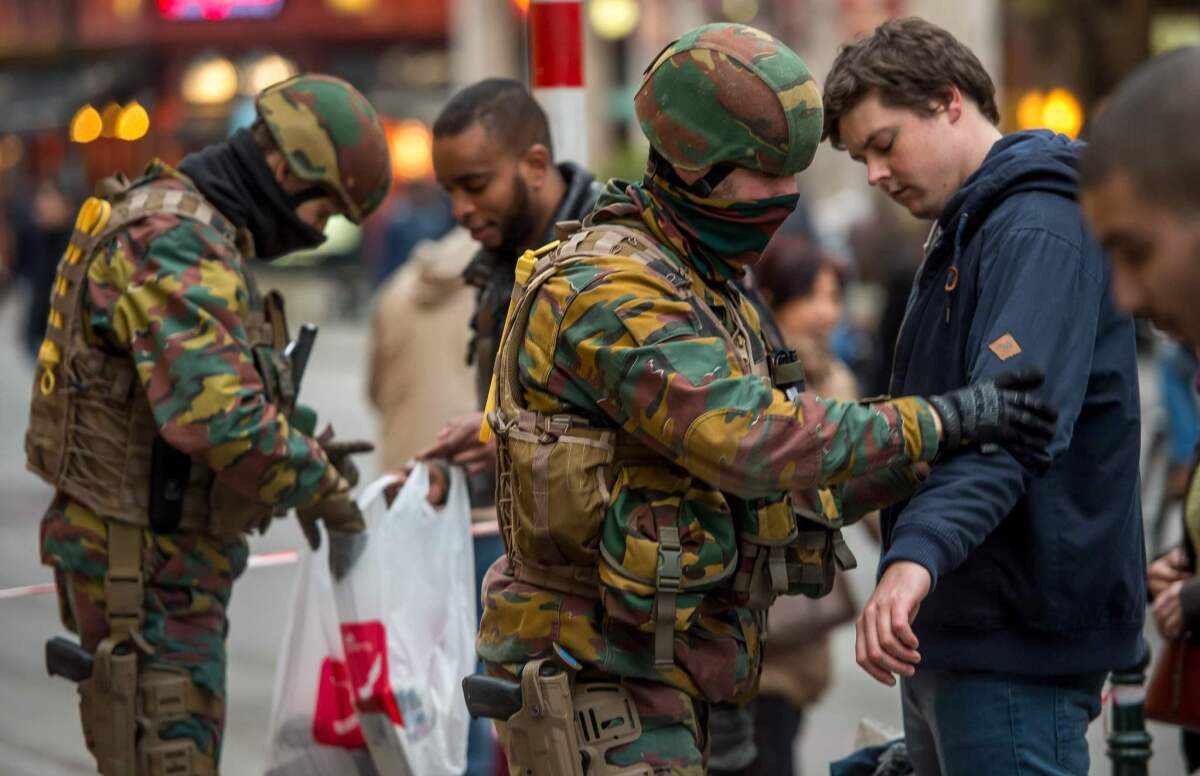 Police search passengers at the entrance of a metro station in Brussels on Thursday.