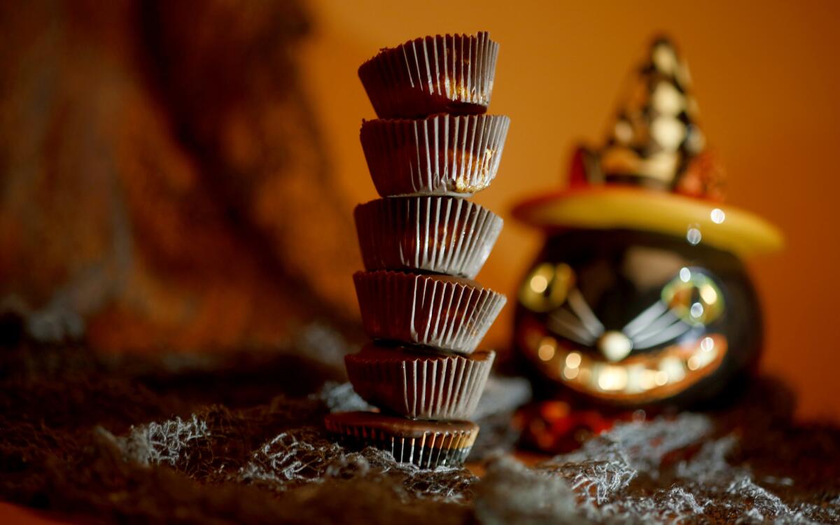 A stack of homemade peanut butter cups with Halloween decorations in the background