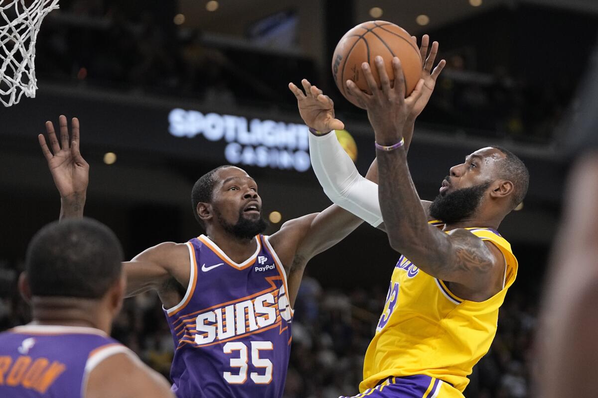 Lakers forward LeBron James shoots as Phoenix Suns forward Kevin Durant defends.