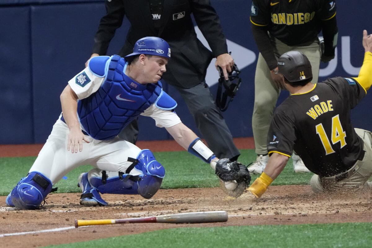 The Padres' Tyler Wade scores as Dodgers catcher Will Smith makes a late tag on March 21 in Seoul