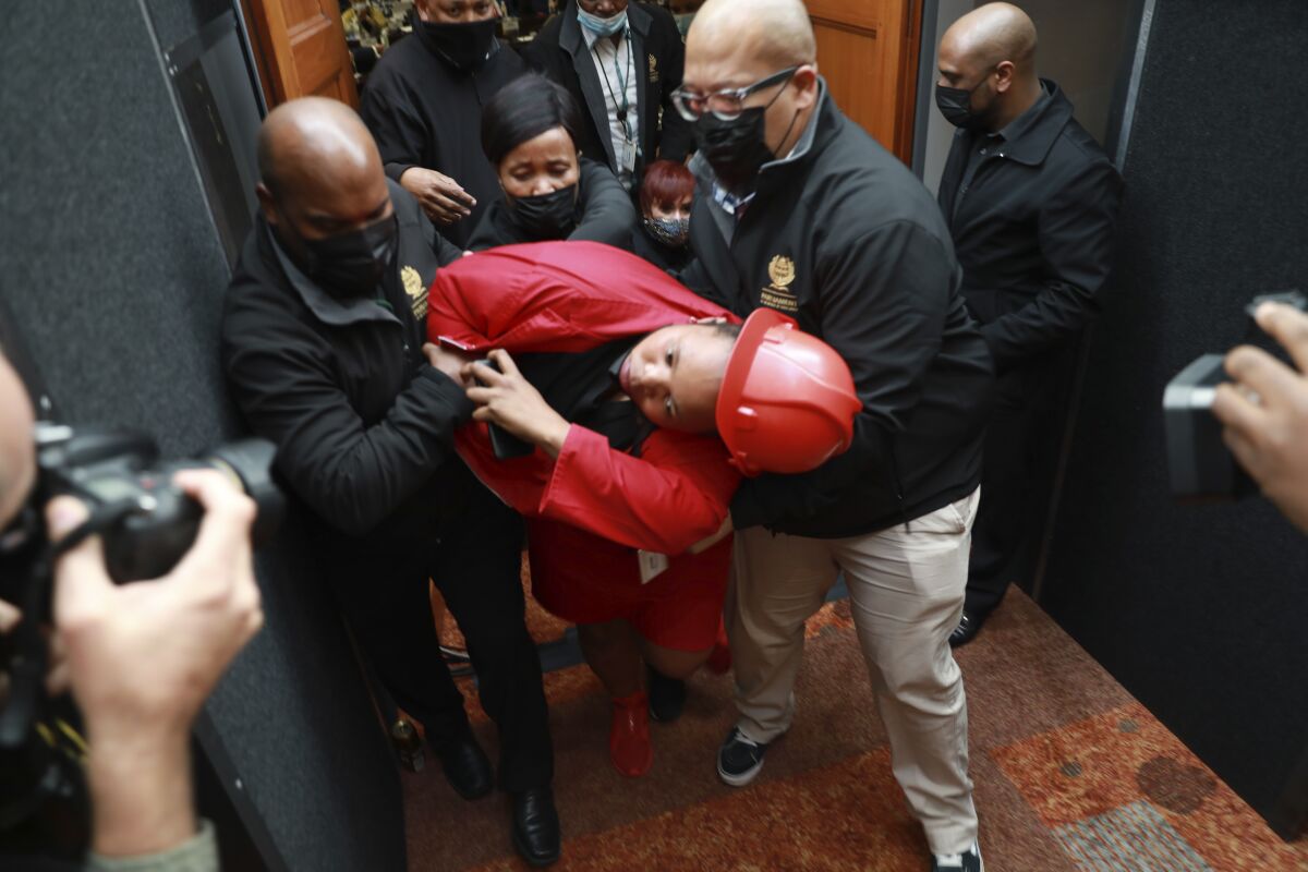A members of the opposition, Economic Freedom Fighters (EFF) party is ejected from parliament in Cape Town, South Africa, Thursday, June 9, 2022 for disrupting proceedings. South African President Cyril Ramaphosa is facing the biggest challenge to his presidency and is expected to face calls from opposition lawmakers to step down pending a criminal investigation into allegations that he tried to cover up the theft of $4 million from his game farm in the northern Limpopo province.(AP Photo/Nardus Engelbrecht)