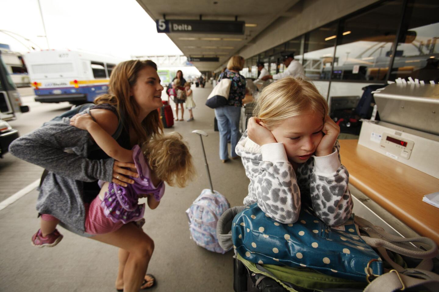 Julia Stein, 7, right, seems a little frustrated as the family heads out on a Florida cruise. To the left, the family nanny, Jai Lust, tries to corral Julia's younger sister, Scarlet, 2.