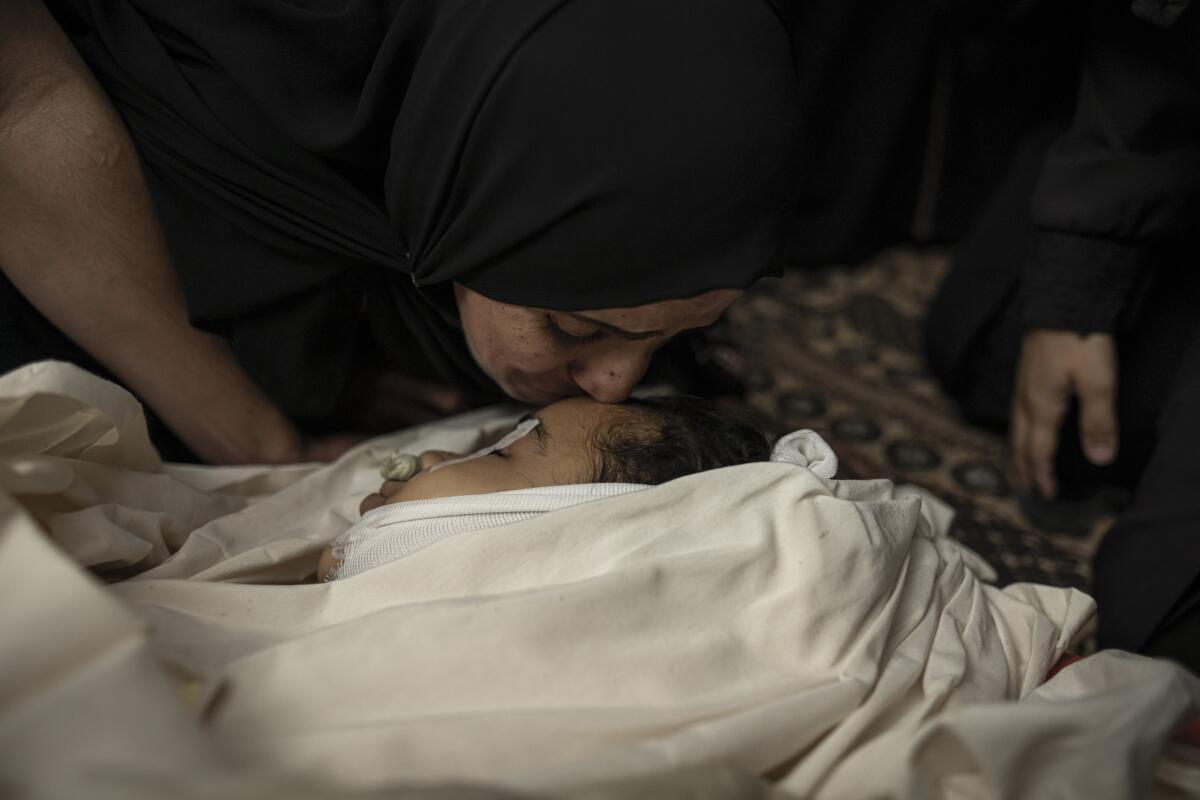 Woman kissing face of dead girl