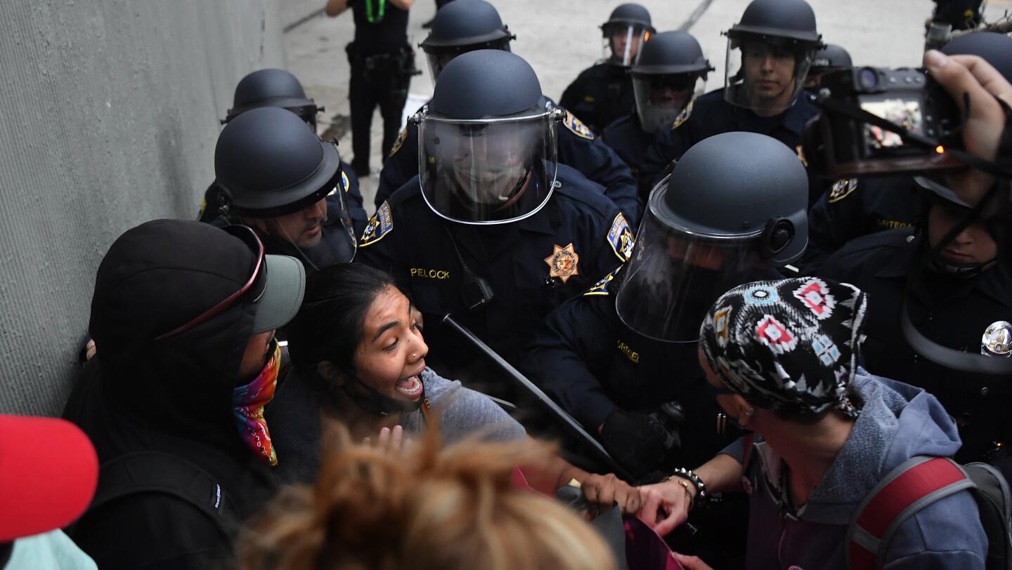 A protester is escorted off the northbound 110 Freeway in downtown Los Angeles.