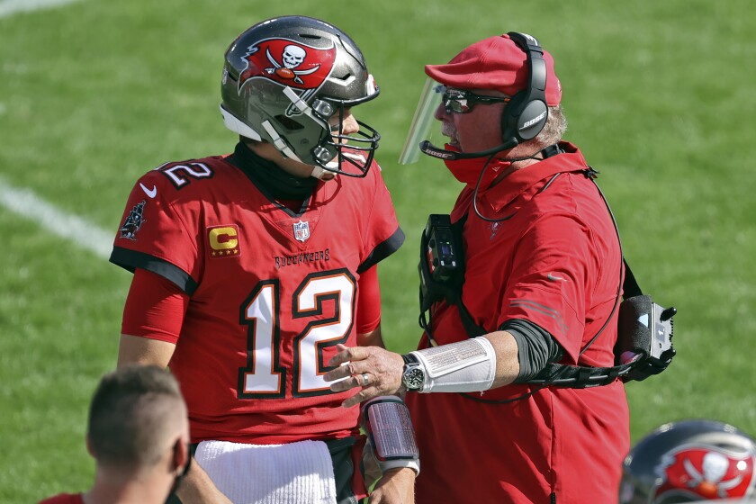Tampa Bay Buccaneers head coach Bruce Arians congratulates quarterback Tom Brady (12) after a touchdown pass to wide receiver Scott Miller (10) during the first half of an NFL football game against the Minnesota Vikings Sunday, Dec. 13, 2020, in Tampa, Fla. (AP Photo/Mark LoMoglio)