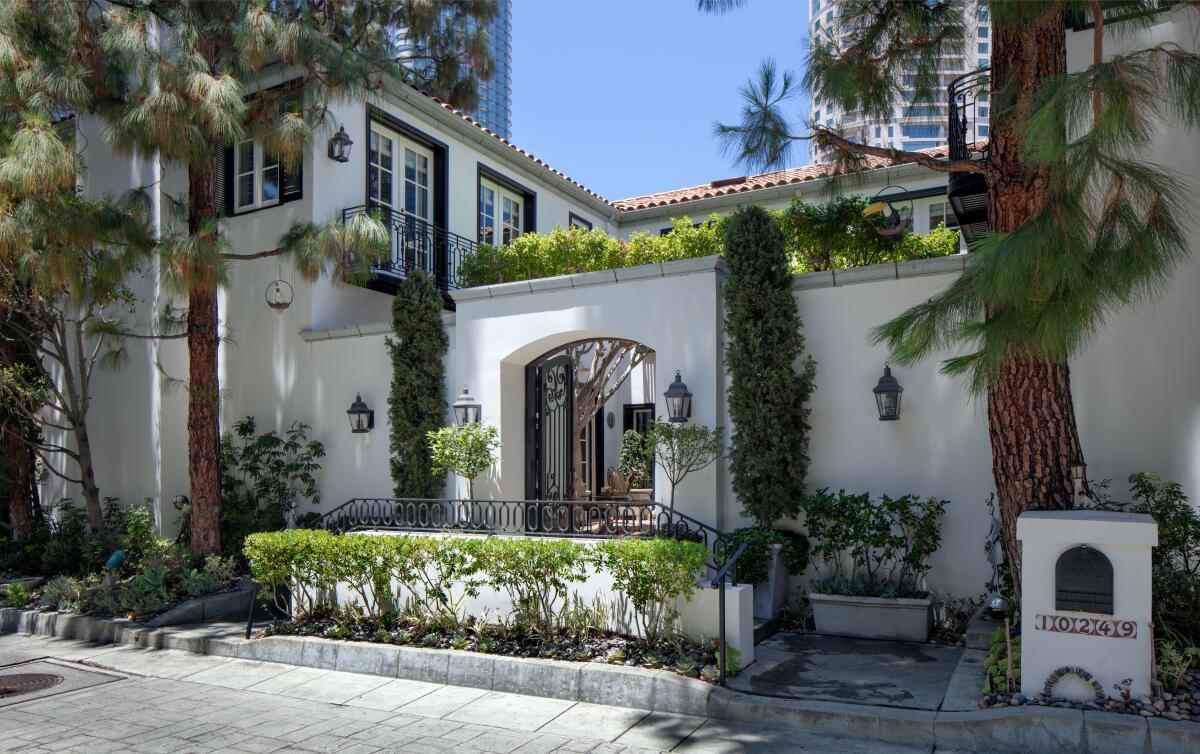 One of 36 homes in a guard-gated enclave, the two-story villa is navigated by an elevator and sweeping staircase.