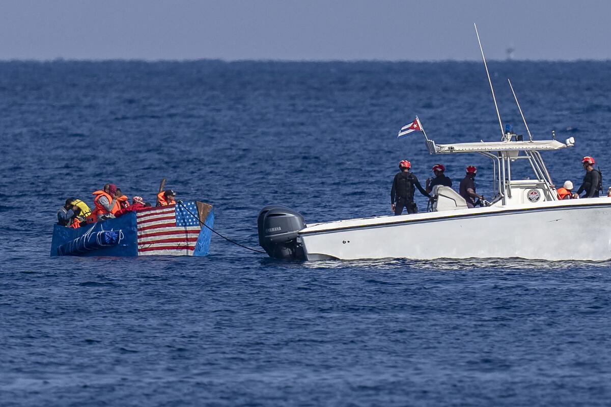 ARCHIVO - Personas en un barco improvisado con la bandera estadounidense