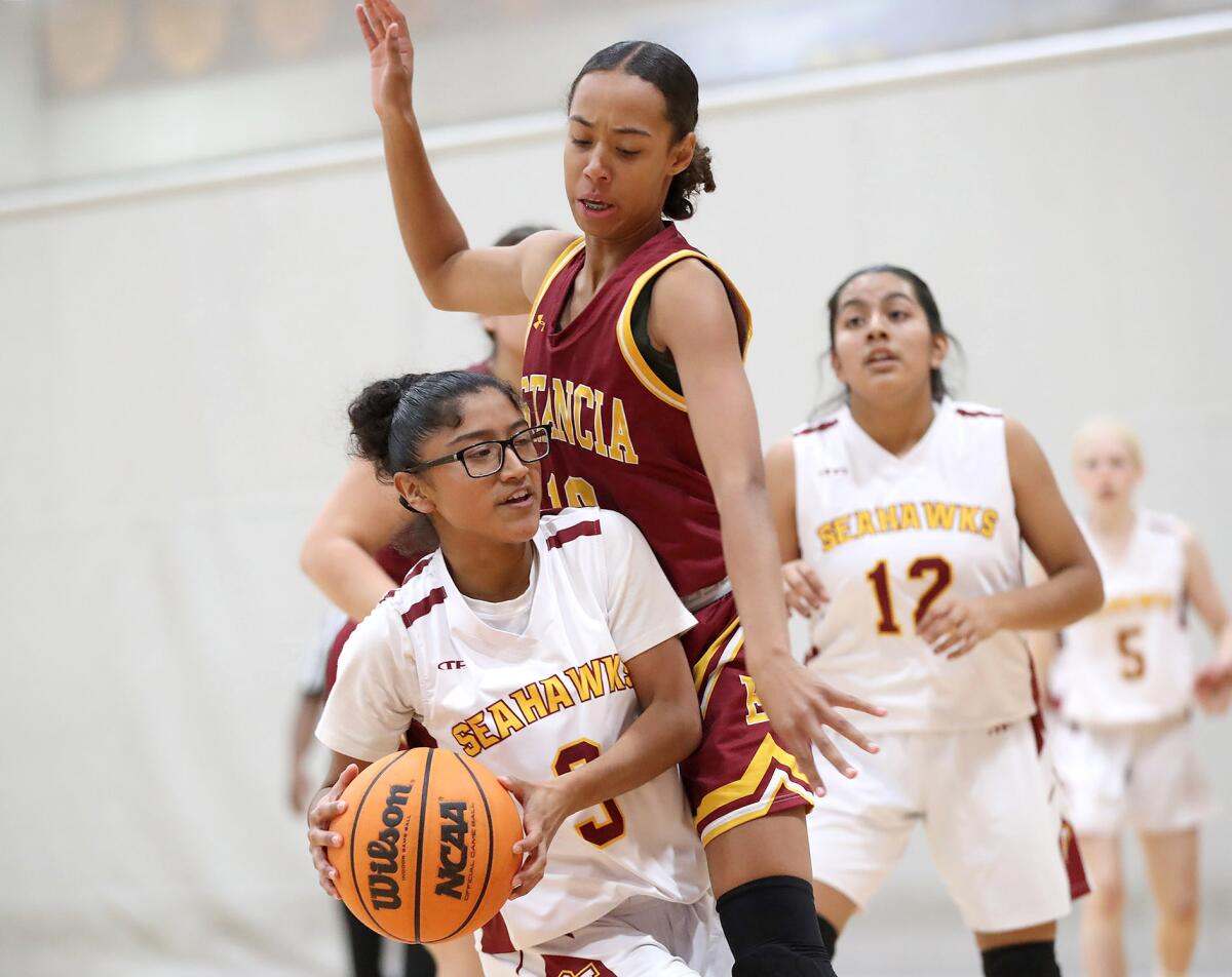 Ocean View's Diana Cardoso (3) is defended by Estancia's Jaydin McClure as she drives to the basket on Wednesday.